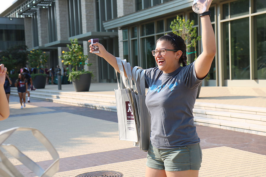 Student intern, Vita Tijerina, gestures to students at a tabling event in the Fall of 2017.